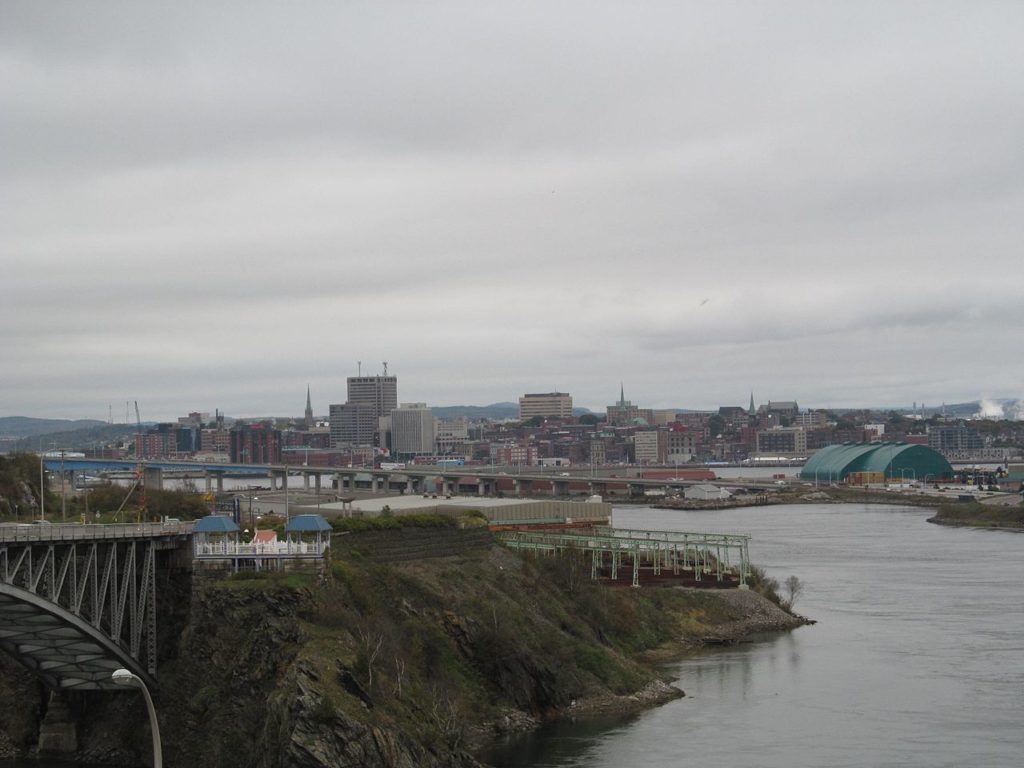 The skyline of Saint John, New Brunswick, outlined against a backdrop of dramatic clouds.